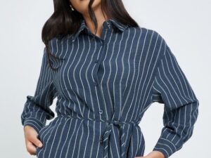 Navy blue striped shirt crafted from a poly blend fabric. Features a collared neckline, long